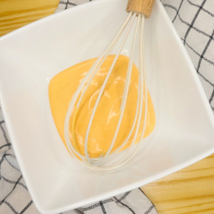 Homemade burger sauce in a white bowl with a whisk