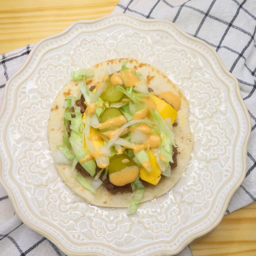 Assembled tortilla burger laying flat on a plate
