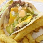 Two Tortilla Burgers with french fries on a plate