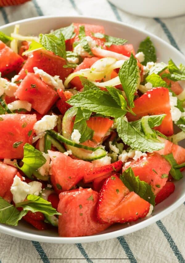 Overhead image of Watermelon Feta Salad in a white bowl on a striped cloth
