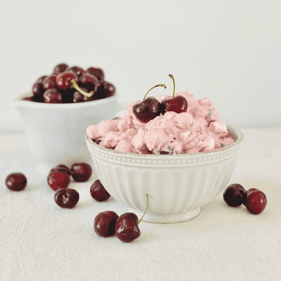 Cherry fluff in a white bowl next to another bowl of cherries