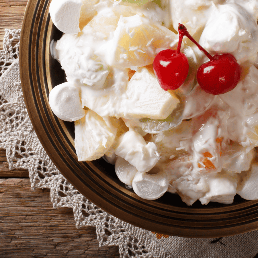 Close up image of fruit salad with cool whip in a brown bowl