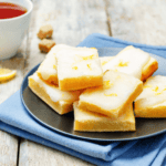 Close up image of lemon brownies stacked on a plate