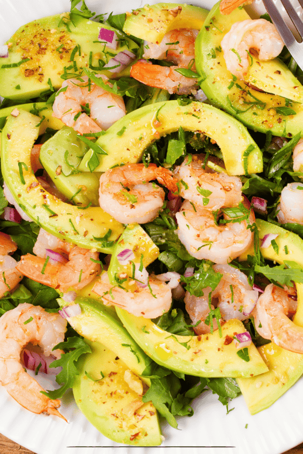 Overhead image of a shrimp salad on a white plate