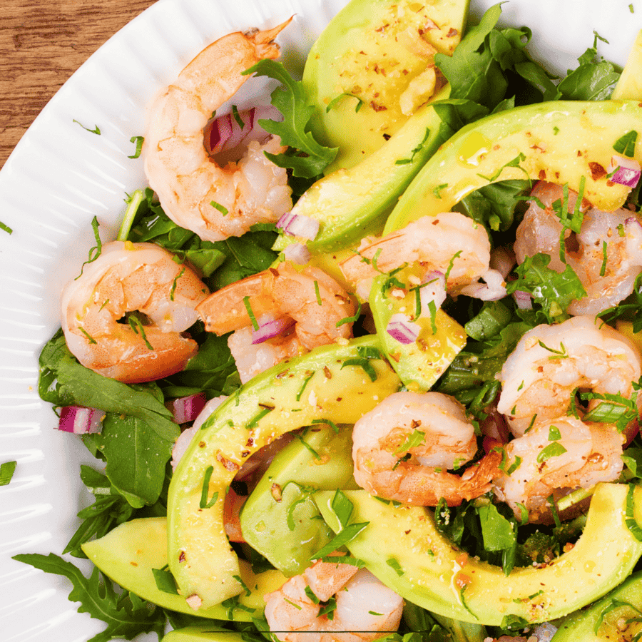 Close up image of a shrimp salad on a white plate