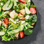 Close up image of a spinach salad in a shallow bowl - 9