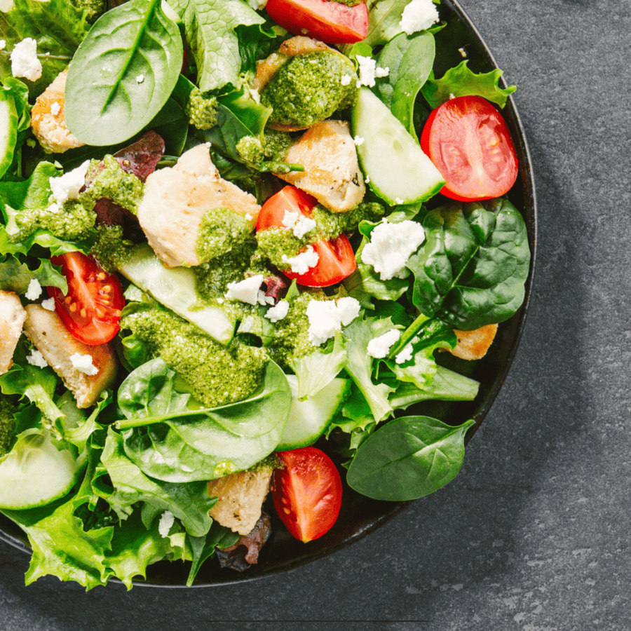 Close up image of a spinach salad in a shallow bowl