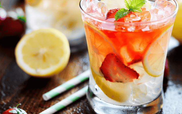 Strawberry lemonade in a glass with strawberry and lemon garnish