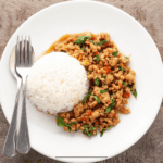Overhead image of Thai Basil Chicken on a white plate with rice - 9