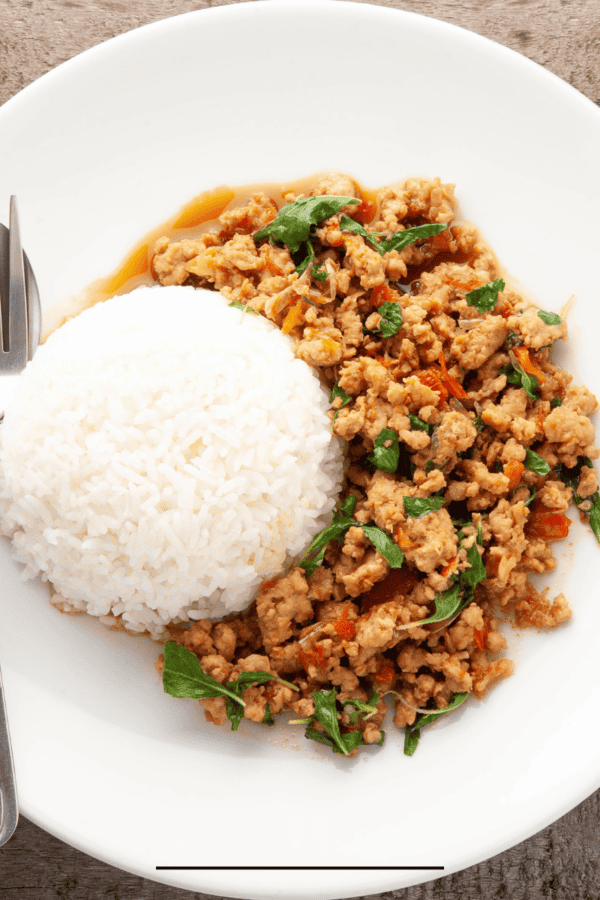 Overhead image of Thai Basil Chicken on a white plate with rice
