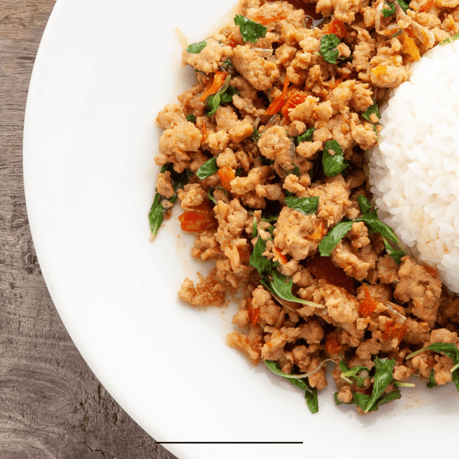 Close up image of Thai Basil Chicken on a white plate with rice