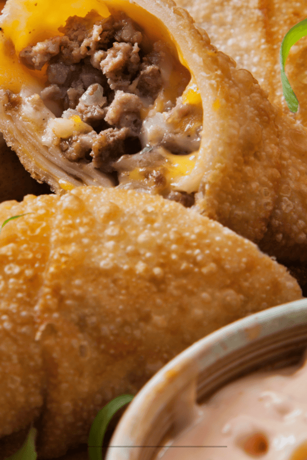 Close up image of a cheeseburger egg roll cut in half