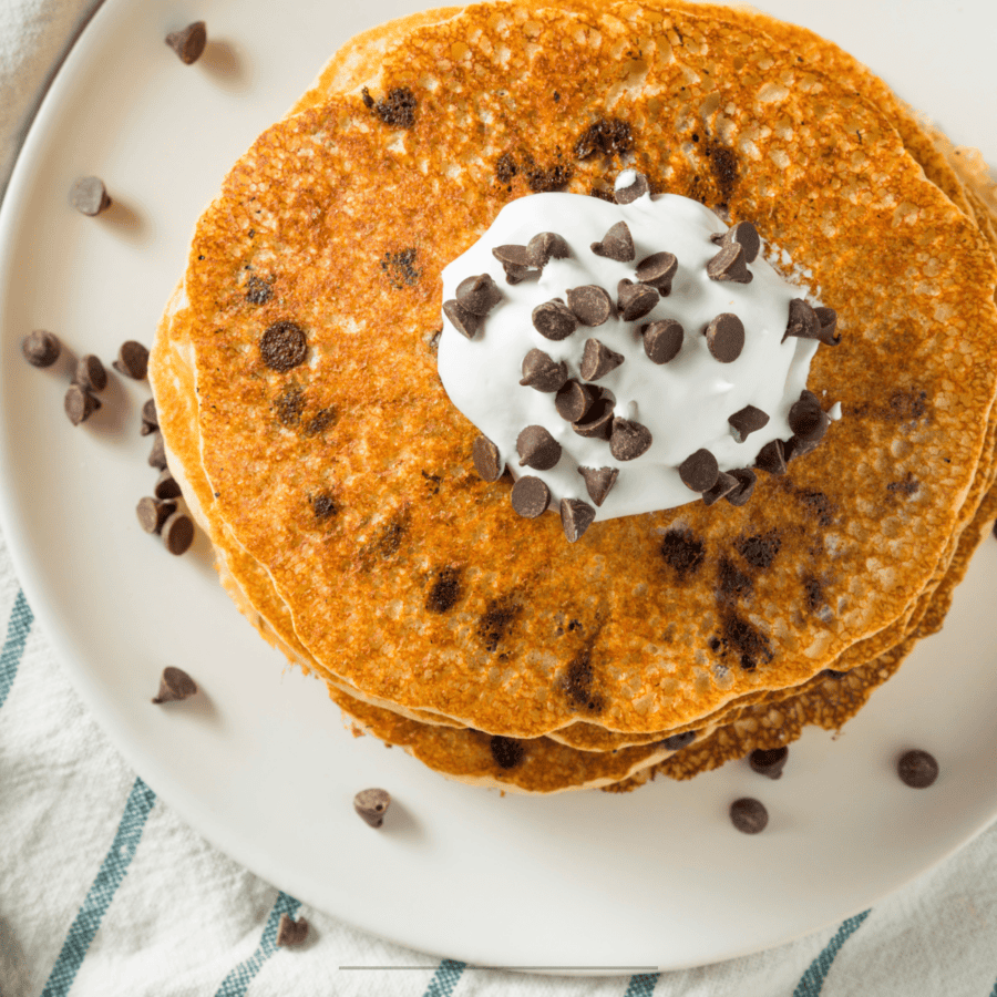 Overhead image of chocolate chip pancakes on a white plate