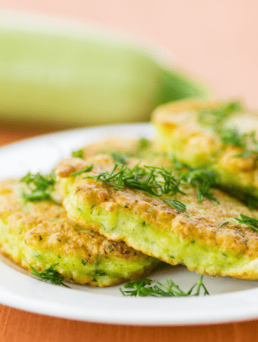 Close up image of zucchini pancakes on a white plate
