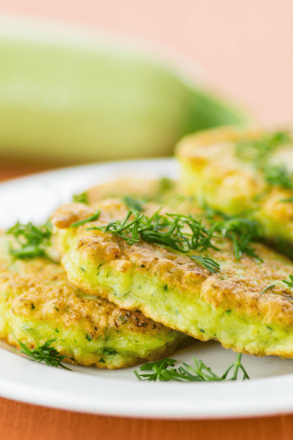 Close up image of zucchini pancakes on a white plate
