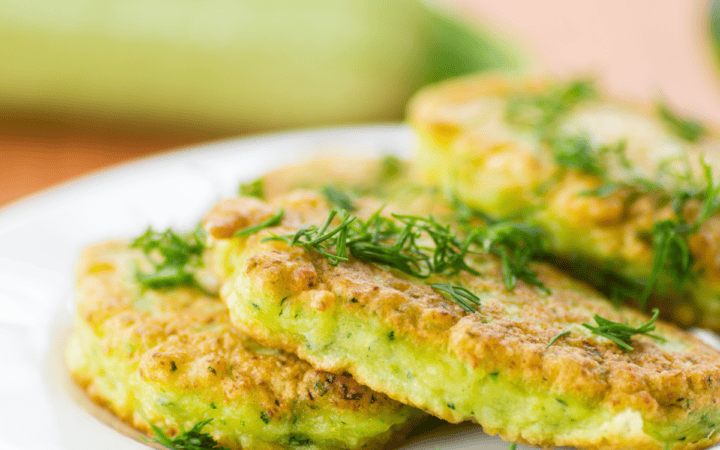 Close up image of zucchini pancakes on a white plate