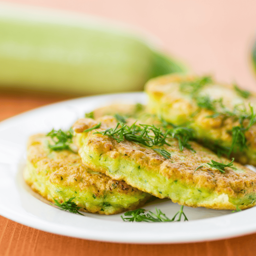 Close up image of zucchini pancakes on a white plate