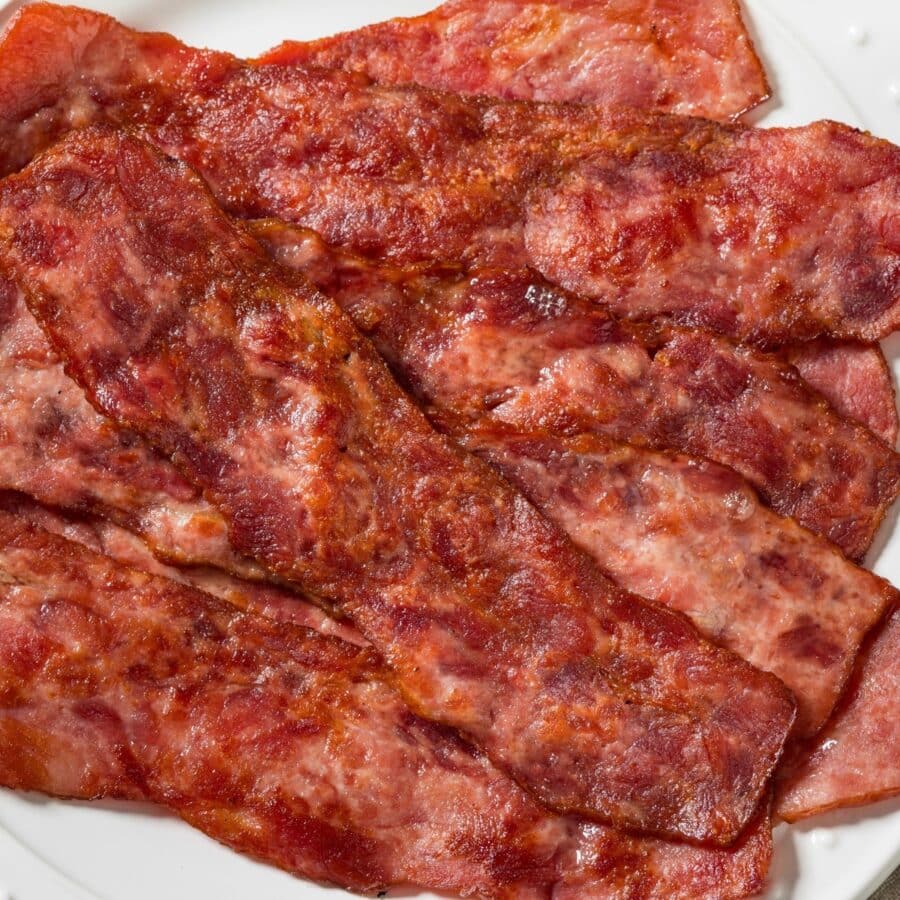 Air Fryer Turkey Bacon stacked on a white plate