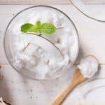 Overhead image of Coconut Ice Cream in a glass bowl with a wooden spoon - 7