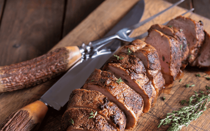 Sliced Grilled Pork Tenderloin on a wooden cutting board