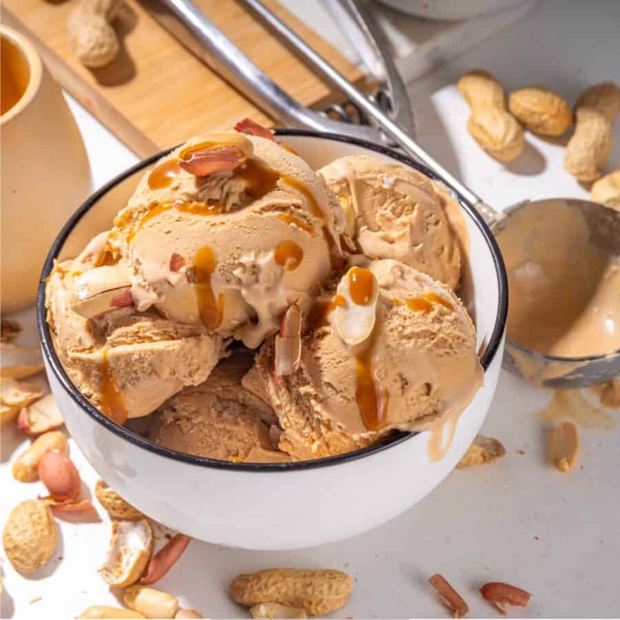 Close up image of peanut butter ice cream in a white bowl with black rim