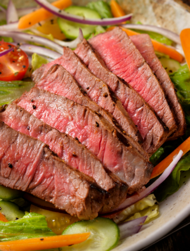 Overhead image of steak salad in a white bowl