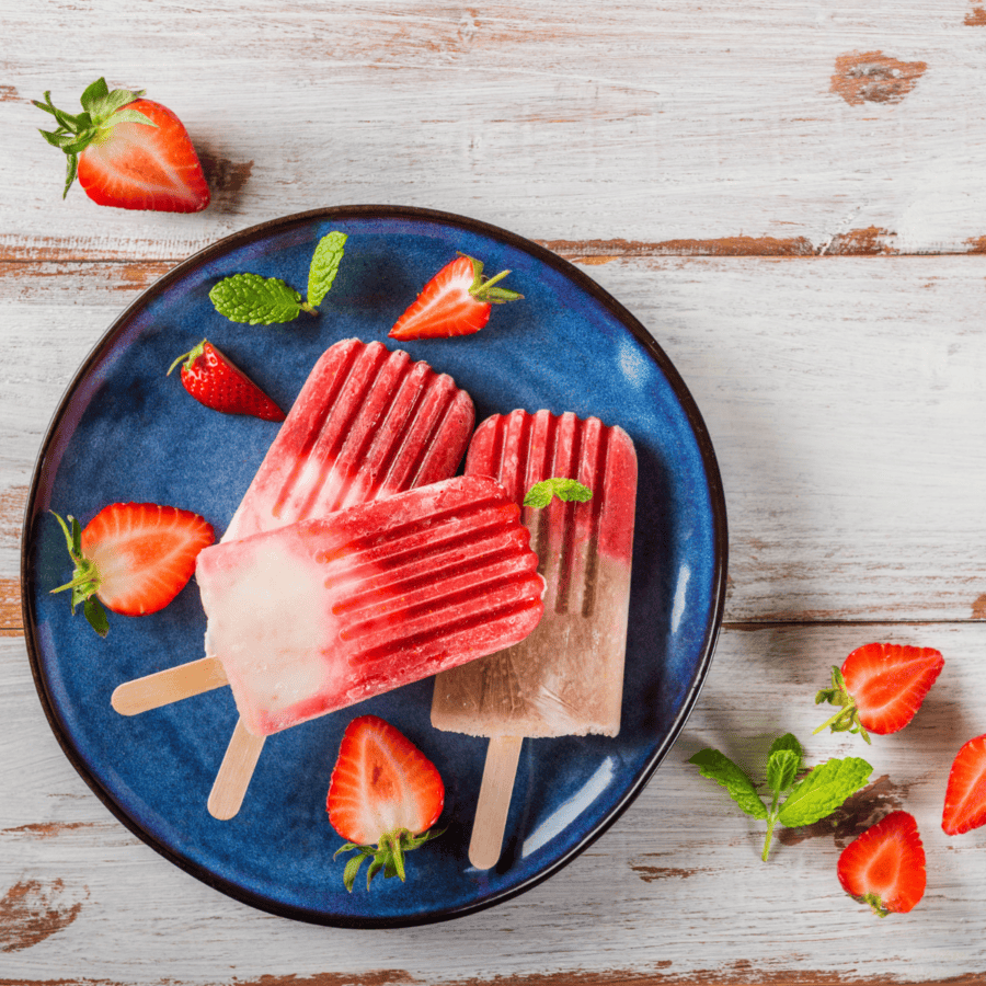 Three Strawberry Popsicles on a blue plate
