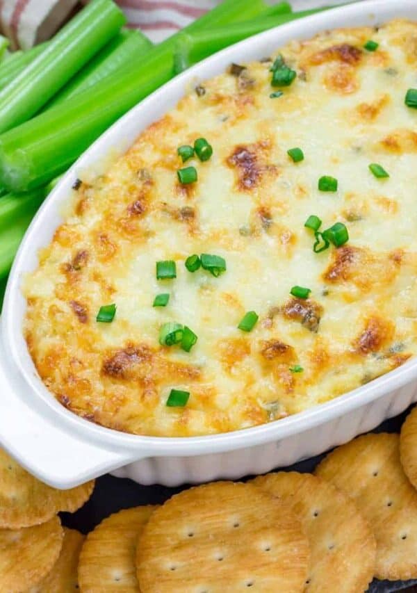 Overhead image of Maryland Crab Dip in a white oval baking dish surrounded by crackers and celery