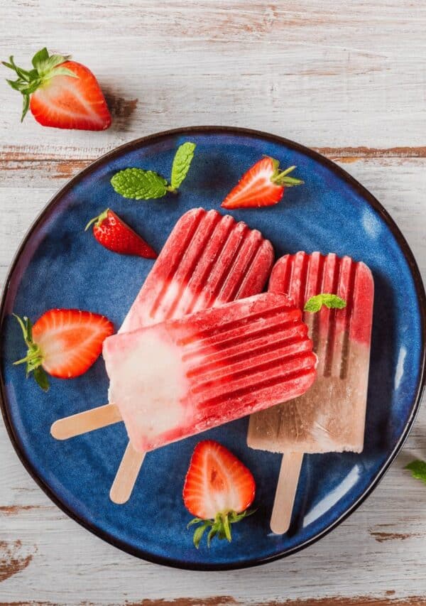 Three Strawberry Popsicles on a blue plate