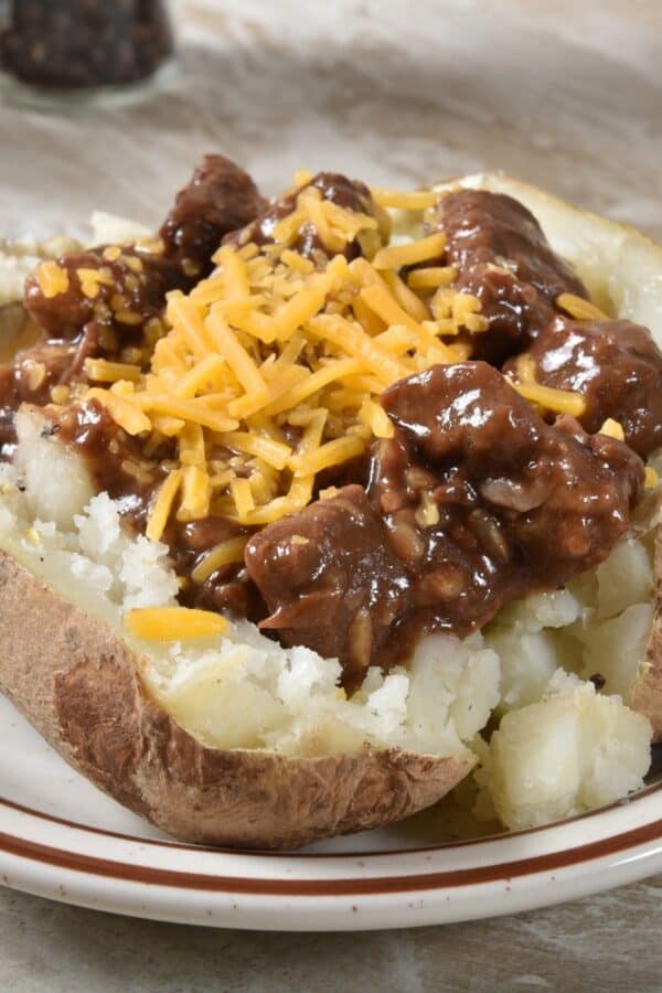 Beef Tips in Gravy on top of a baked potato