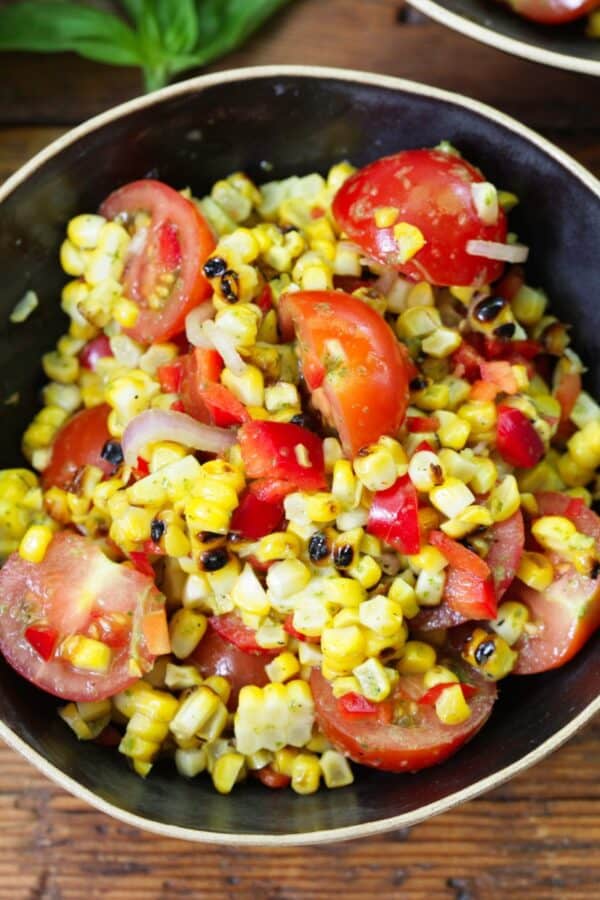 Overhead image of Corn and Tomato Salad in a black bowl