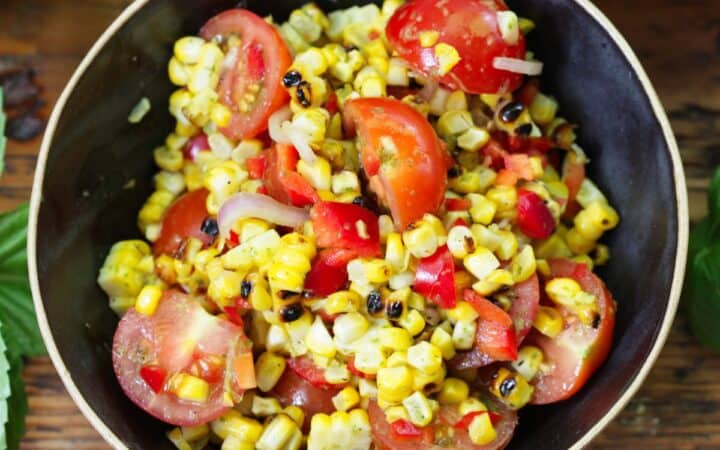 Overhead image of Corn and Tomato Salad in a black bowl