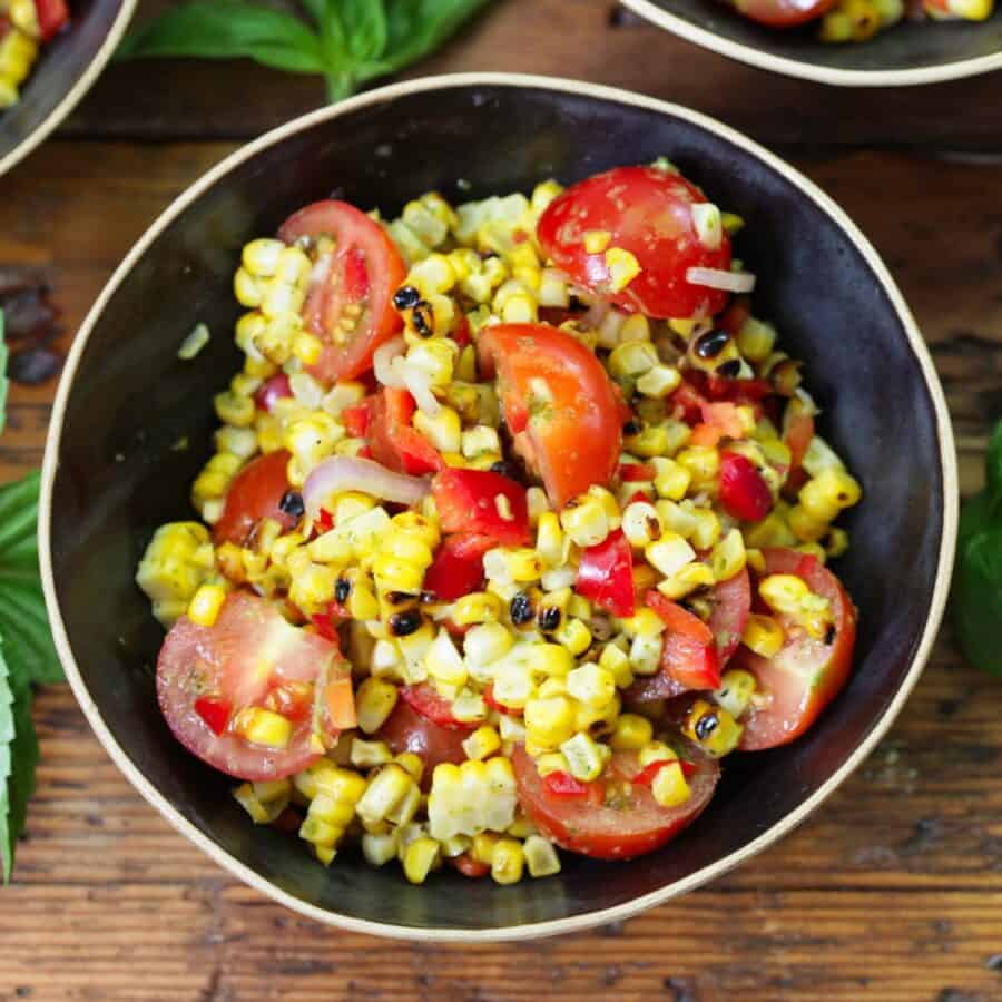 Overhead image of Corn and Tomato Salad in a black bowl