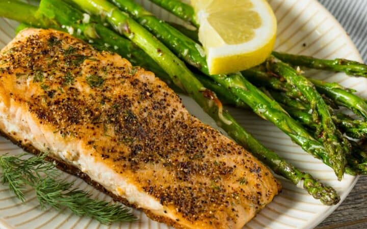 Pan Seared Salmon on a white plate with asparagus