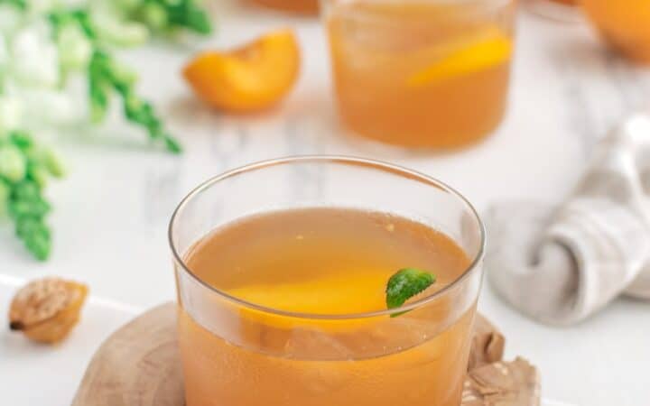 Glasses of Peach Lemonade on a decorative wooden plank