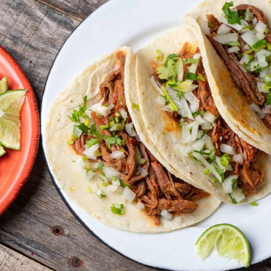 overhead image of three slow cooker barbacoa tacos