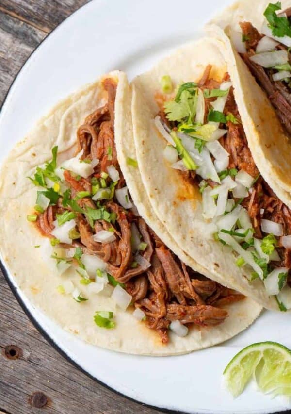 overhead image of three slow cooker barbacoa tacos