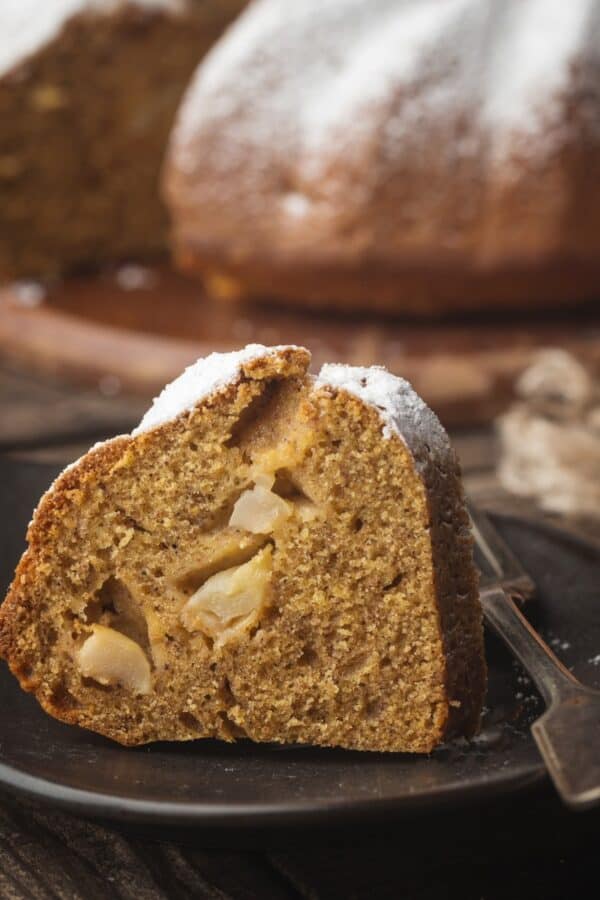 A slice of Apple Bundt Cake on a small black plate