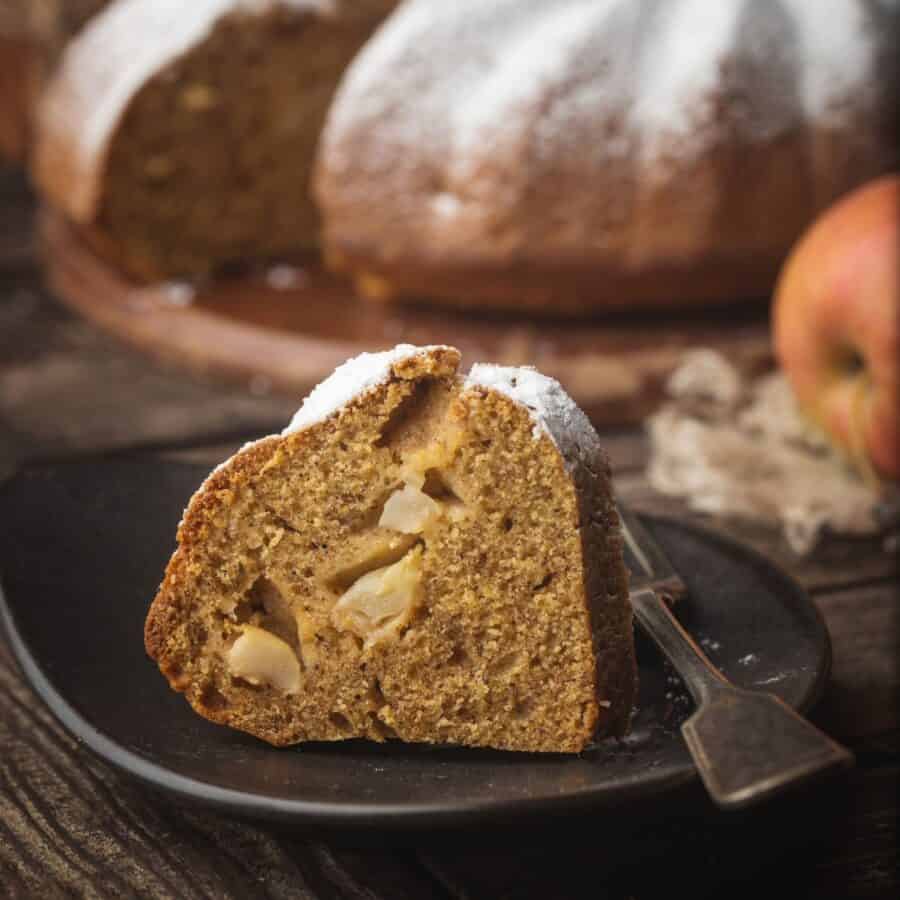 A slice of Apple Bundt Cake on a small black plate