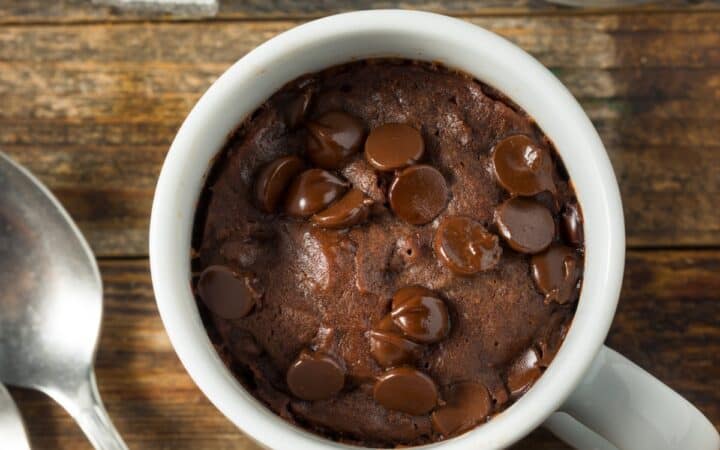 Overhead image of a brownie in a mug on a wooden surface