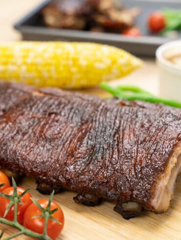 Close u image of baked ribs on a wooden cutting board