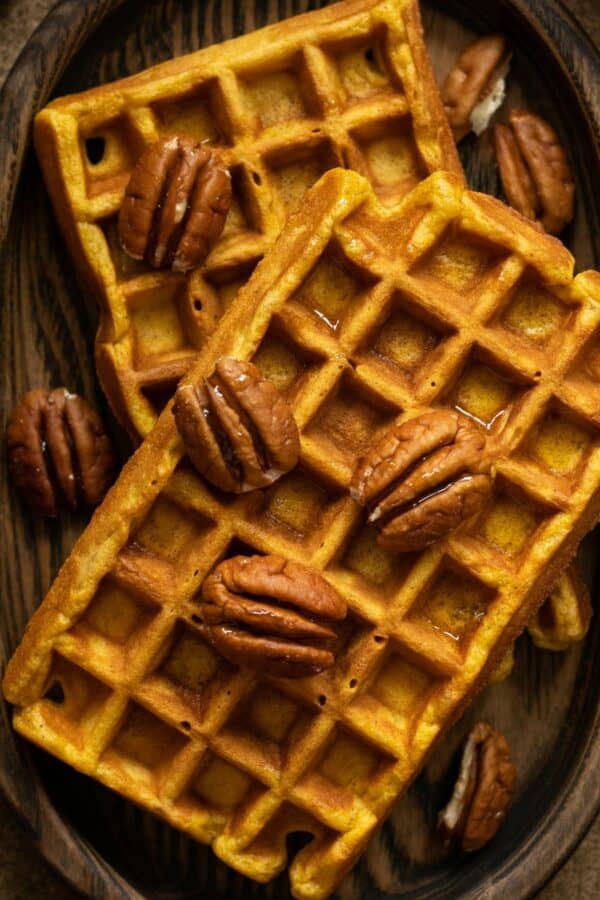 Overhead image of pumpkin pecan waffles on a wooden plate