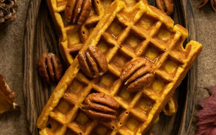 Overhead image of pumpkin pecan waffles on a wooden plate