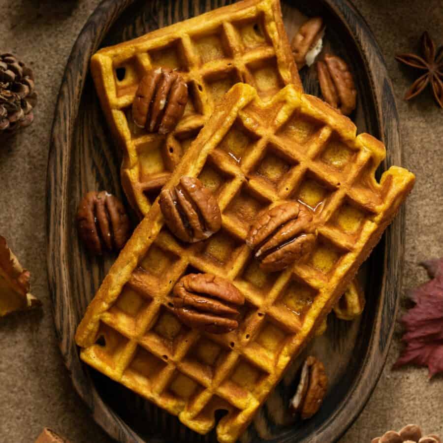 Overhead image of pumpkin pecan waffles on a wooden plate