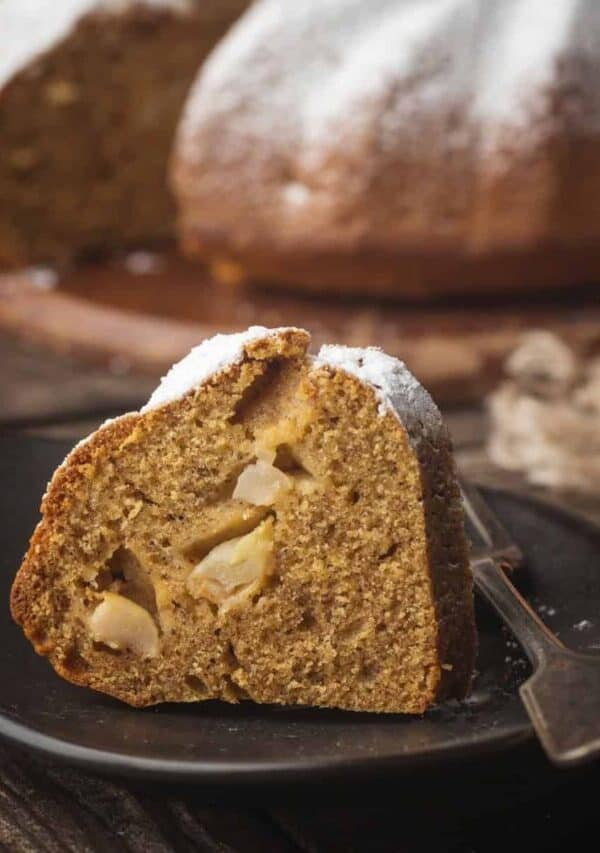 A slice of Apple Bundt Cake on a small black plate