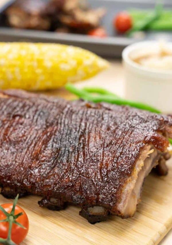 Close u image of baked ribs on a wooden cutting board