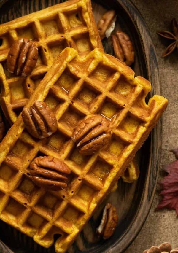 Overhead image of pumpkin pecan waffles on a wooden plate