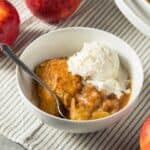 A white bowl full of Apple Cobbler and a scoop of vanilla ice cream - 7