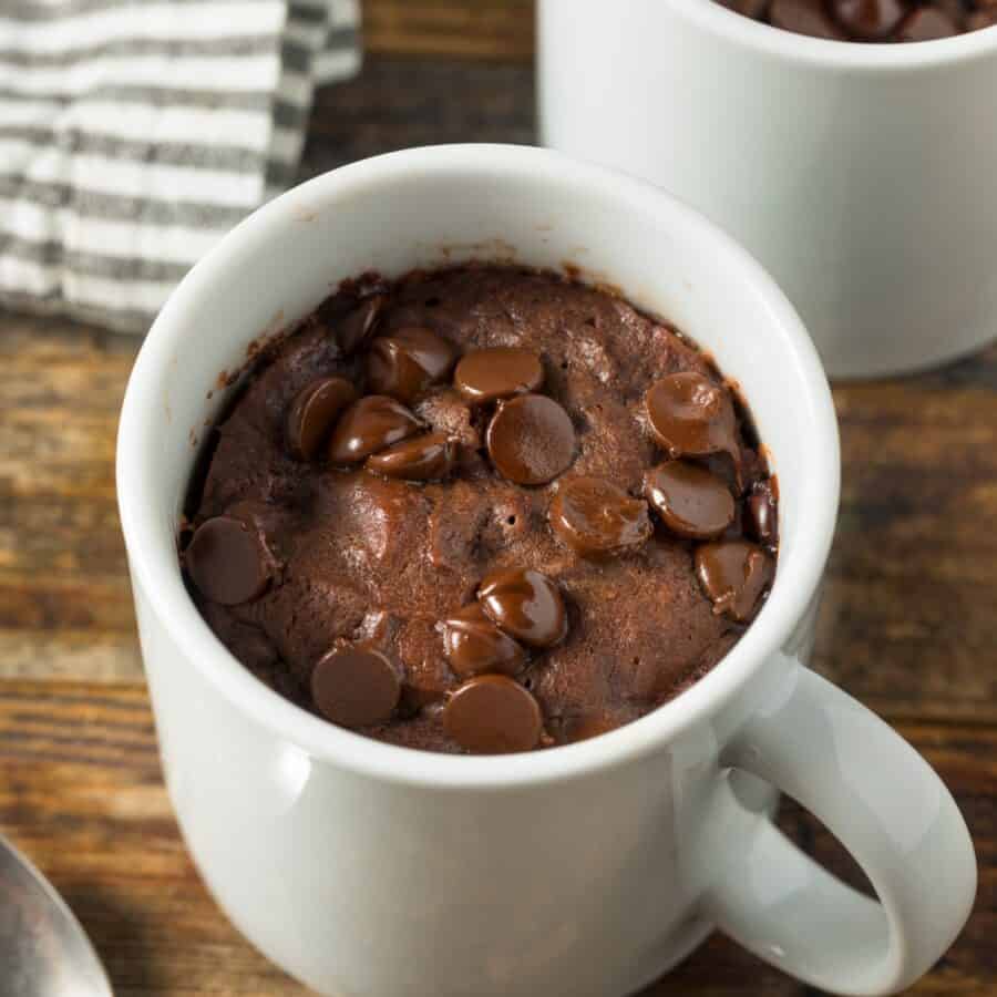 Two servings of Brownie In A Mug on a wooden surface