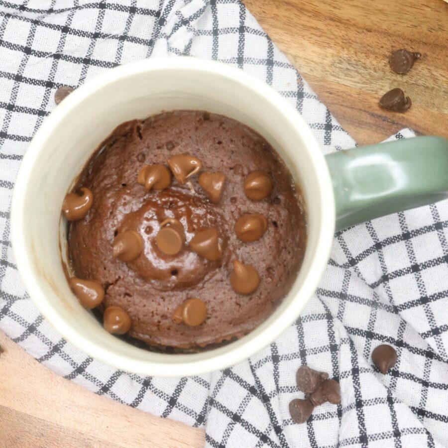 Overhead image of a Brownie in a mug on a plaid cloth